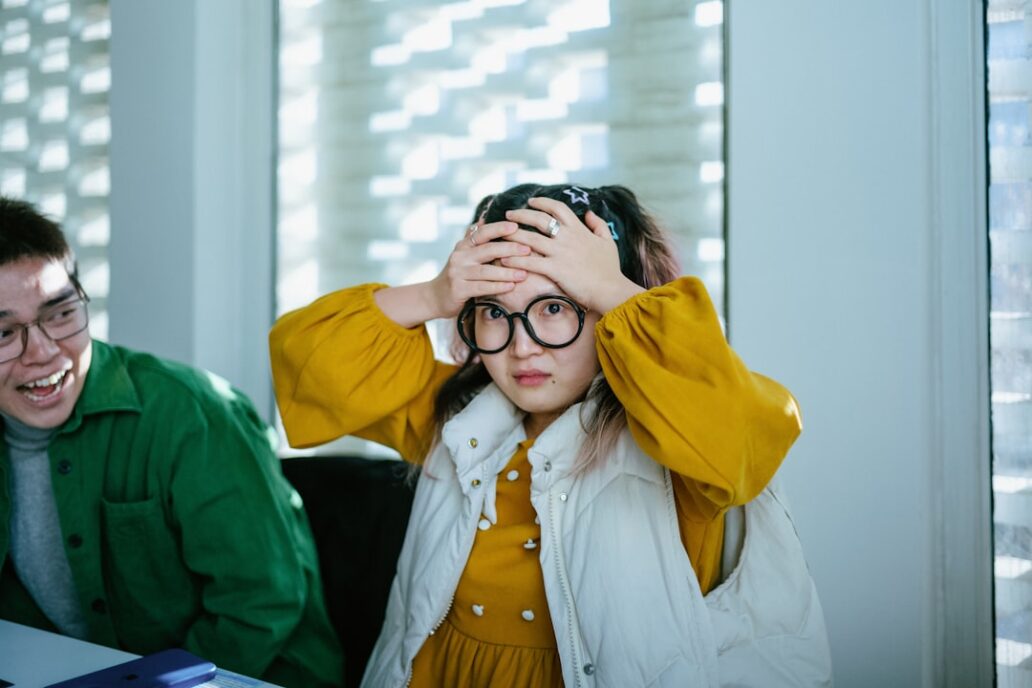 a boy and a girl sitting at a table with a laptop